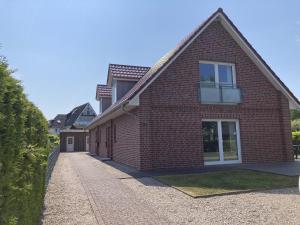 a red brick house with a window and a driveway at Kellenhusen - Ferienhaus Gabi in Kellenhusen