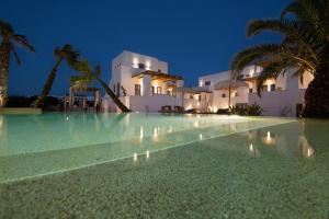 a swimming pool in front of a villa at night at Kosmitis Suites & Villas in Naousa