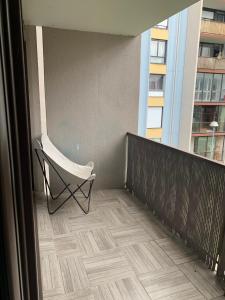 białe krzesło siedzące na balkonie budynku w obiekcie L'Escale - appartement spacieux au calme w mieście Brest