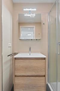 uma casa de banho com um lavatório e um chuveiro em Cloche d'Or Proximity - Sleek Urban Space em Luxemburgo