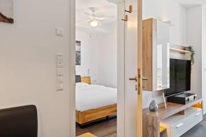 a room with a bed and a tv and a sliding door at Cloche d'Or Proximity - Sleek Urban Space in Luxembourg