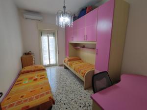 Pokój z 2 łóżkami i różowymi szafkami w obiekcie Casa Vacanza dai Compari w mieście Ali Terme