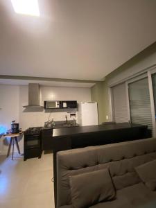 a kitchen with a couch in a living room at Sem Taxas! Studio Central, Moderno e C/ Garagem in Pelotas