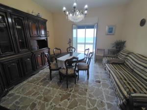 jadalnia ze stołem, krzesłami i kanapą w obiekcie Casa Vacanza dai Compari w mieście Ali Terme