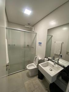 a bathroom with a toilet and a sink and a shower at Sem Taxas! Studio Central, Moderno e C/ Garagem in Pelotas