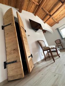 a room with a wooden door and a chair and a surfboard at Hôtel Ambassador Palombaggia in Porto-Vecchio