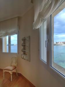 Cette chambre dispose d'une chaise et d'une fenêtre. dans l'établissement Desconectaengalicia San Isidro, a pie de playa Silgar, à Sanxenxo