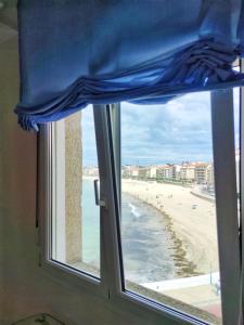 - une fenêtre avec vue sur la plage et l'océan dans l'établissement Desconectaengalicia San Isidro, a pie de playa Silgar, à Sanxenxo
