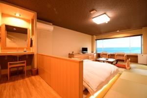 una camera da letto con un letto e una grande finestra di 黒潮の宿 臨海荘 -Kuroshio no yado Rinkaisou- a Katsuura