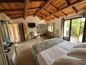a bedroom with a large bed and a large window at Hôtel Ambassador Palombaggia in Porto-Vecchio