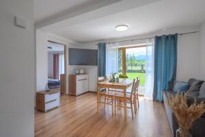 a kitchen and living room with a table and chairs at Pokoje Gościnne MAGNAS in Poronin