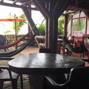 a table and chairs with a playground and swings at Hotel Bambu Mompiche in Mompiche