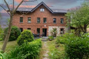 a brick house with a patio in front of it at Agroturystyka Ziemia Obiecana in Nielestno