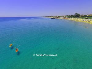 an aerial view of a beach with people in the water at Villa Falconara in Noto