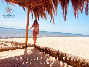 a woman in a bikini standing on a beach at New Bella Sina Camp in Nuweiba