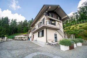 a building with a balcony and stairs on a hill at Bellosta Family Country Club MB Alpe Moiana in Armeno