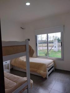 a bedroom with two bunk beds and a window at La casita de Isa in Gualeguay