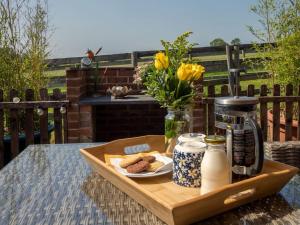 Puck's Retreat Bed & Breakfast في Tredington: صينية مع الخبز والحليب على طاولة مع الزهور