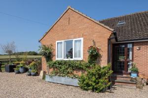 a brick house with plants on the side of it at Puck's Retreat Bed & Breakfast in Tredington