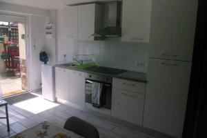 a kitchen with white cabinets and a stove top oven at appartement autonome in Prémilhat