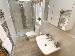 a bathroom with a sink and a shower and a toilet at 8 Waterside Wood in Windermere +10 photos