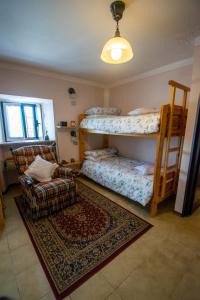 a room with two bunk beds and a rug at Bellosta Family Country Club MB Alpe Moiana in Armeno