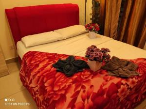 a bed with a red headboard and flowers on it at CQ3311- SELF CHECK-IN- WI-FI- NETFLIX- PARKING-BALCONY - CYBERJAYa , 2018 in Cyberjaya