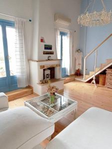 a living room with a fireplace and a glass table at Blue & White Cycladic house - 100m from the beach in Megas Gialos - Nites