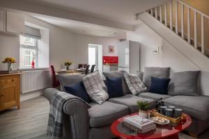 ein Wohnzimmer mit einem Sofa und einem Tisch in der Unterkunft NEW Luxurious Escape Charming Dog Friendly Cottage in Caernarfon