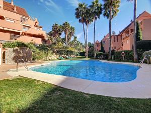 カサーレスにある2231 - Amazing 3 bedrooms with 3 sunny terracesのヤシの木が茂る庭のスイミングプール