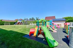 einen Spielplatz mit Rutsche im Gras in der Unterkunft Villa Konwalia in Grzybowo