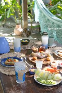 una mesa con platos de comida y bebidas. en Pousada Villa Serena, en Caraíva