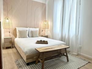 - une chambre avec un grand lit et une table en bois dans l'établissement LE PLUMAÇON - Agréable - Proche Gare, à Mont-de-Marsan