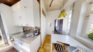 una cocina con armarios blancos y fregadero en Second Home Apartments Asplund, en Solna