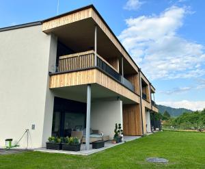 een modern huis met een balkon en een tuin bij kleines Seeglück in Feldkirchen in Kärnten