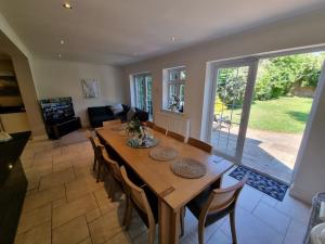 ein Esszimmer mit einem Holztisch und Stühlen in der Unterkunft 6 Bedroom Huge Holiday Home with parking in Luton