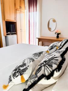 un letto con cuscini bianchi e neri sopra di Apartments Đurašević a Sveti Stefan