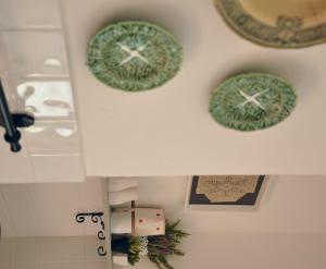 two green plates on the wall in a bathroom at Casa18.55 - Time with history in São Brás de Alportel