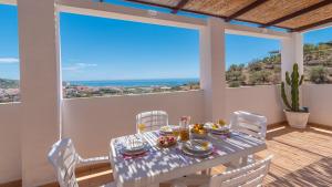 een eetkamer met een tafel en stoelen op een balkon bij Villa Diego Torrox by Ruralidays in Torrox