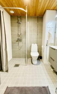 a bathroom with a shower and a toilet in it at Modern family apartment next to metro easy access to Helsinki in Espoo
