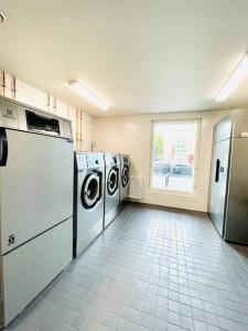 a laundry room with washing machines and a window at Modern family apartment next to metro easy access to Helsinki in Espoo