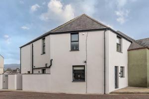 a white house with a black roof at NEW Luxurious Escape Charming Dog Friendly Cottage in Caernarfon