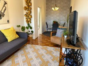 sala de estar con sofá y TV en Apartamento Trindade, en Oporto