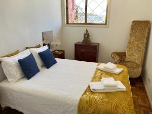 Un dormitorio con una cama con almohadas azules y una silla en Apartamento Trindade, en Oporto