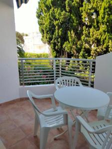 uma mesa branca e cadeiras sentadas numa varanda em Margaritas em Alcossebre