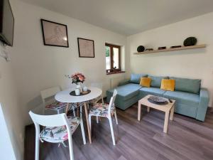 uma sala de estar com um sofá, uma mesa e cadeiras em Rezidence GreenHill ⃰ ⃰ ⃰ em Kraslice