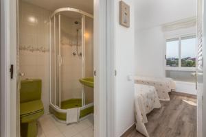 bagno con servizi igienici verdi e lavandino di La Escala a L'Escala Altre 12 foto