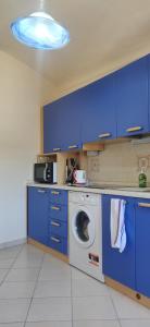 une cuisine avec des armoires bleues et un lave-linge dans l'établissement Dolce Vita Alta Ventimiglia, à Vintimille