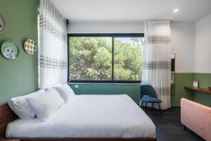een slaapkamer met een bed en een groot raam bij Carmel Suites by Olala Homes in Haifa
