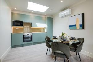 cocina y comedor con mesa y sillas en Marble Arch Suite 8-Hosted by Sweetstay en Londres